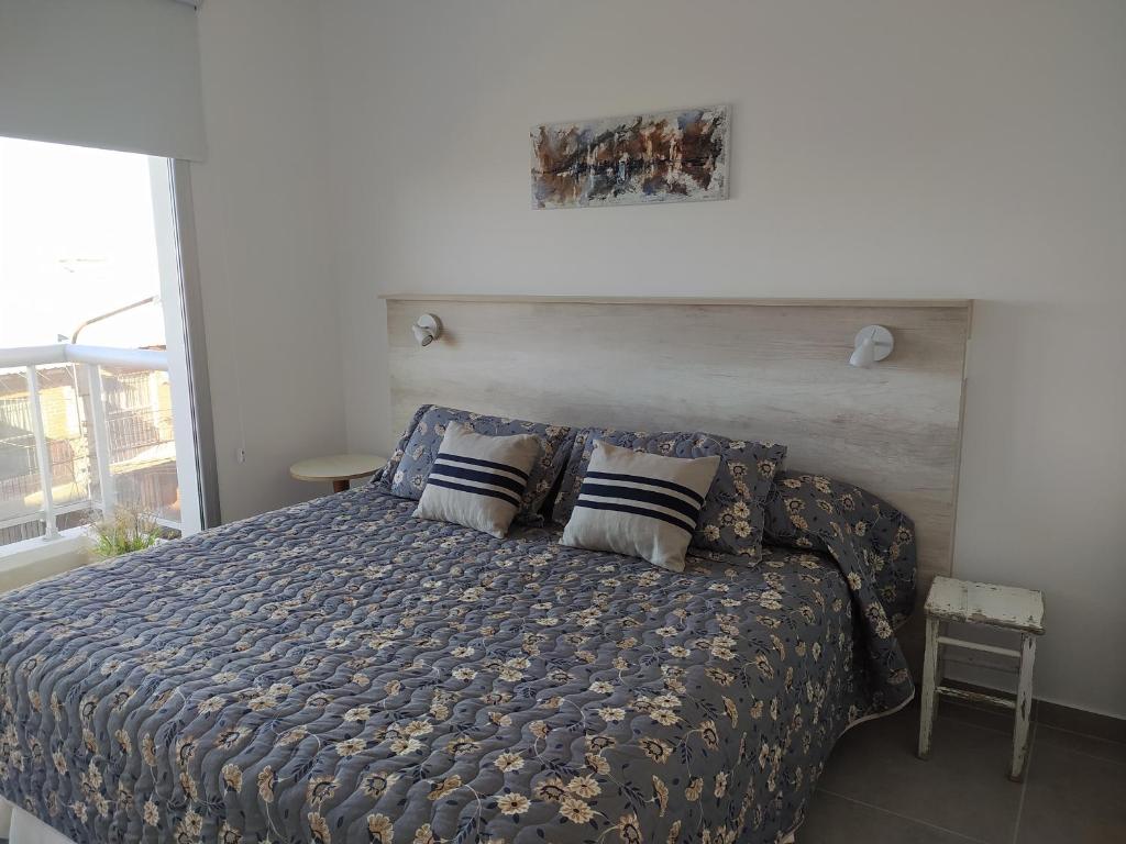 una camera da letto con un letto con piumone e cuscini blu di Del Santo San Rafael a Puerto Madryn