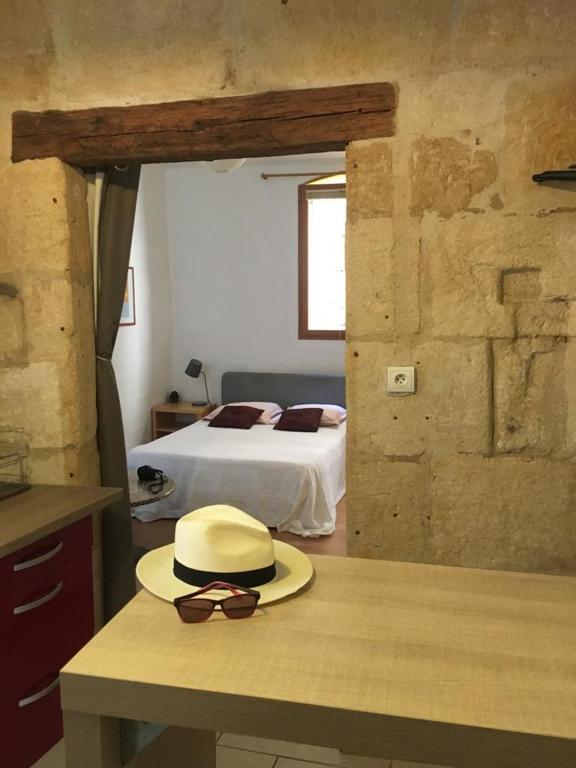 un chapeau et des lunettes de soleil assis sur un comptoir dans une chambre dans l'établissement Appart sympa Nimes centre, à Nîmes