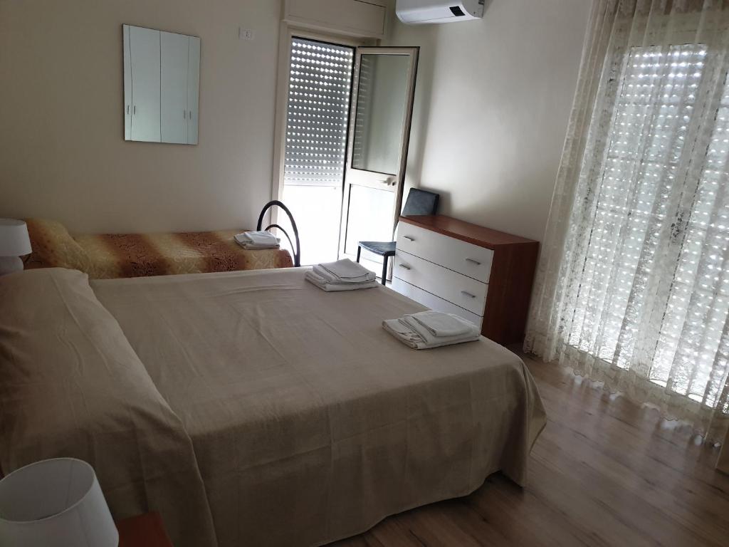 ein Schlafzimmer mit einem Bett, einer Kommode und einem Fenster in der Unterkunft Appartamento Marchese in Racalmuto