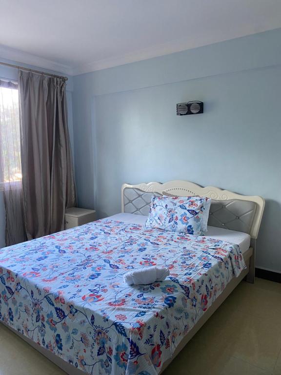 a bedroom with a bed with a blue bedspread at Ocean view Home stay in Dar es Salaam