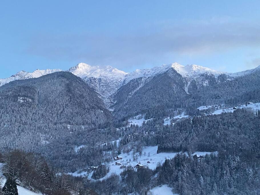 une chaîne de montagnes enneigée avec des arbres et des montagnes enneigées dans l'établissement Appartement à Queige, à Queige