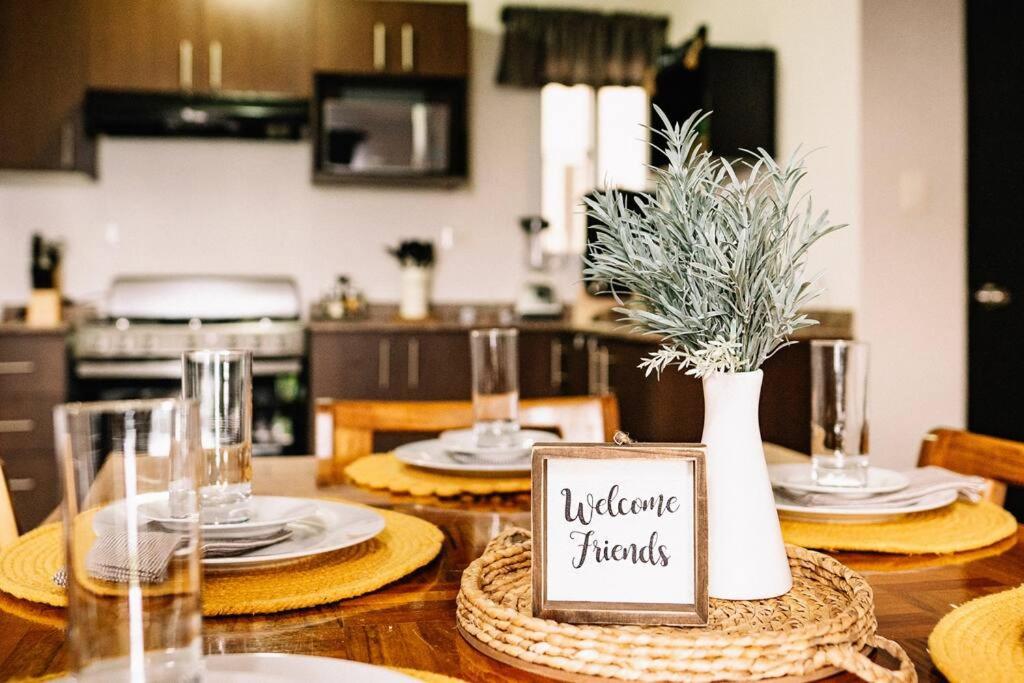 einen Tisch mit einer Vase mit einem Schild, das einzigartige Fäden liest in der Unterkunft Cozy PH Apartment in the City in Guatemala