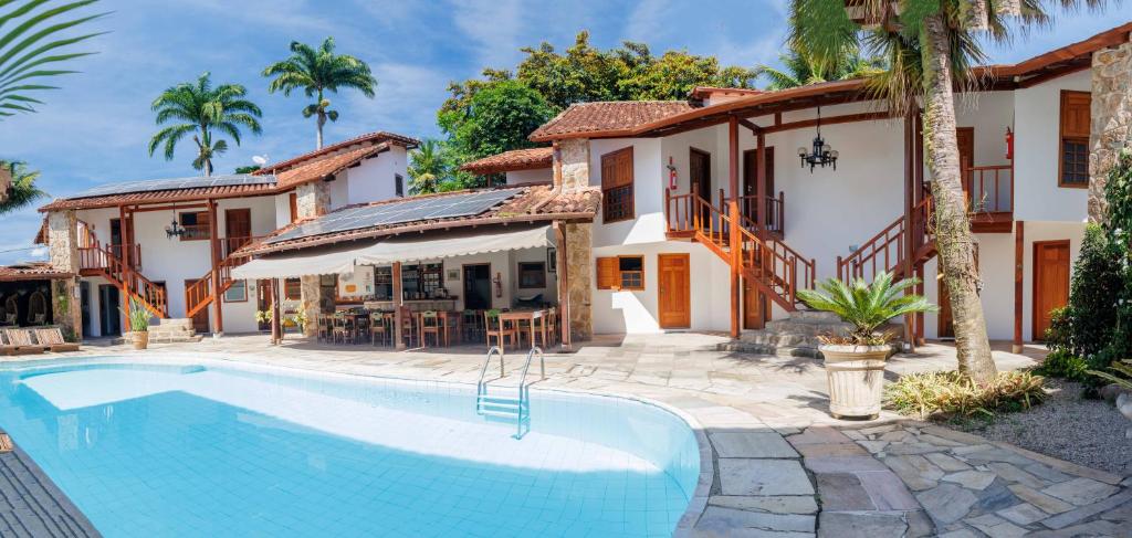 a swimming pool in front of a house at Pousada Valhacouto in Paraty