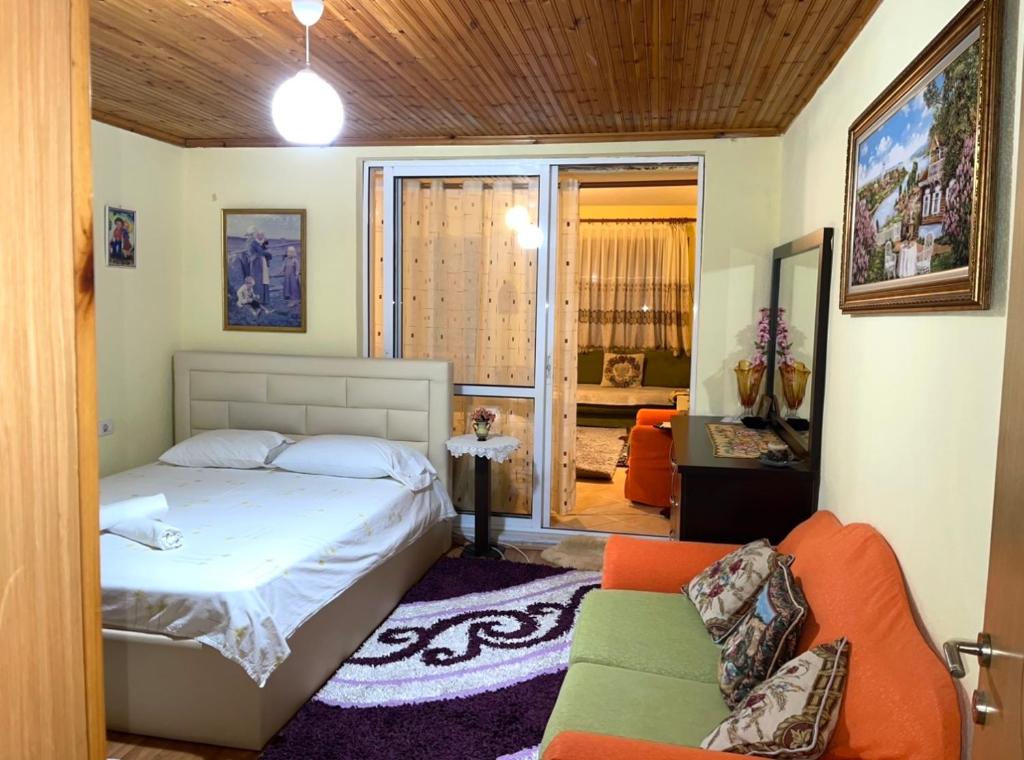 1 dormitorio con 1 cama y 1 sofá en Blue Guesthouse, en Gjirokastra