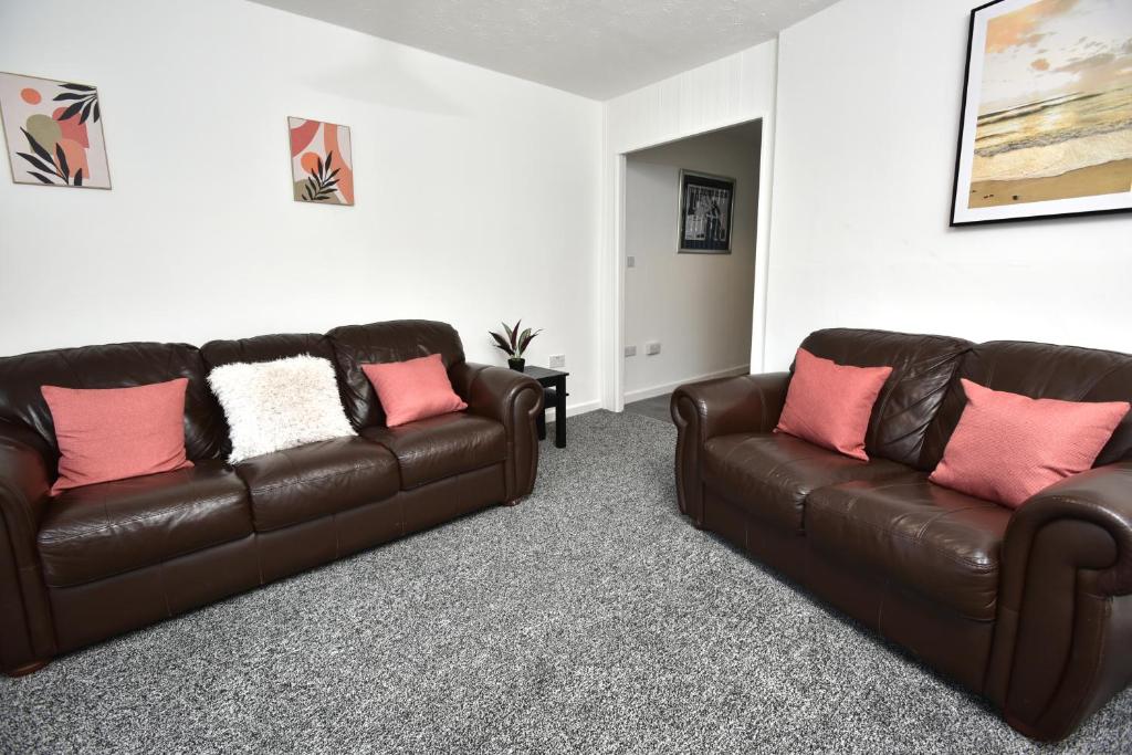 a living room with two brown leather couches at Sedgemoor in Stockton-on-Tees