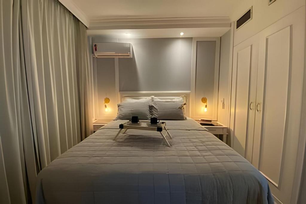 Un dormitorio con una cama con una mesa. en Apartamento Vila Olímpia. en São Paulo