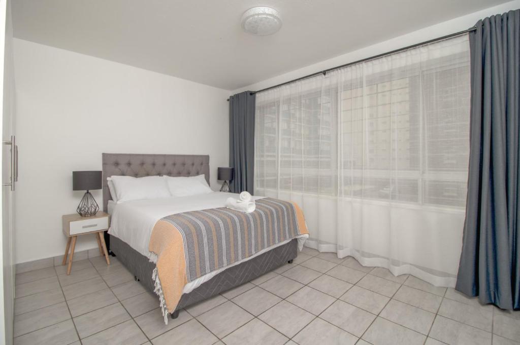 a bedroom with a large bed and a window at Wavecrest 103 Holiday Apartment in Durban
