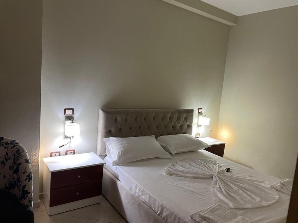 sypialnia z białym łóżkiem i 2 szafkami nocnymi w obiekcie "Nako" apartment w Tiranie