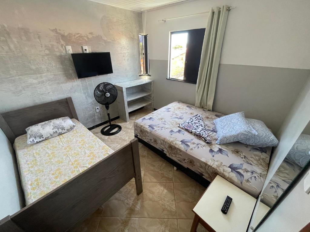 a small bedroom with two beds and a television at Apartamento a 1 km da Orla in Aracaju