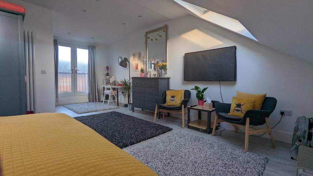 a bedroom with a yellow bed and a flat screen tv at Sidney Grove B&B in Newcastle upon Tyne