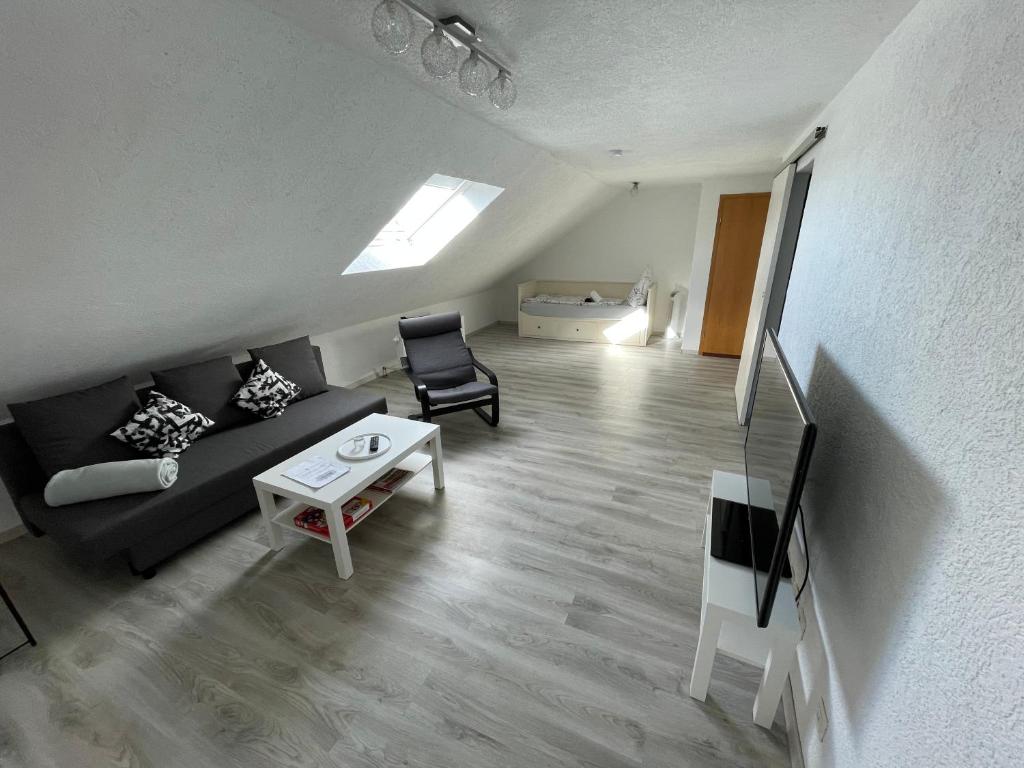 uma sala de estar com um sofá e uma mesa em Moderne gemütliche 2-Zimmer Wohnung Stuttgart Bad-Cannstatt em Stuttgart