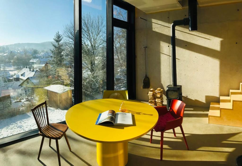 einen gelben Tisch und Stühle in einem Zimmer mit Fenster in der Unterkunft Ferienapartment Burgstrasse Ost in Altleiningen