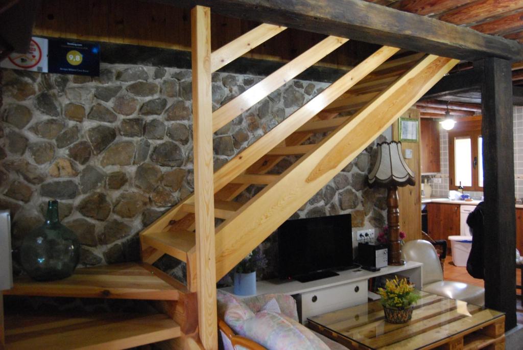 - un lit en mezzanine dans un salon avec un mur en pierre dans l'établissement Arroyo Milano Casa Rural, à Maello