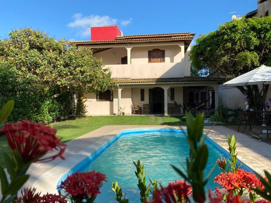 a swimming pool in front of a house at Bela casa de praia, arborizada, um paraíso! in Salvador