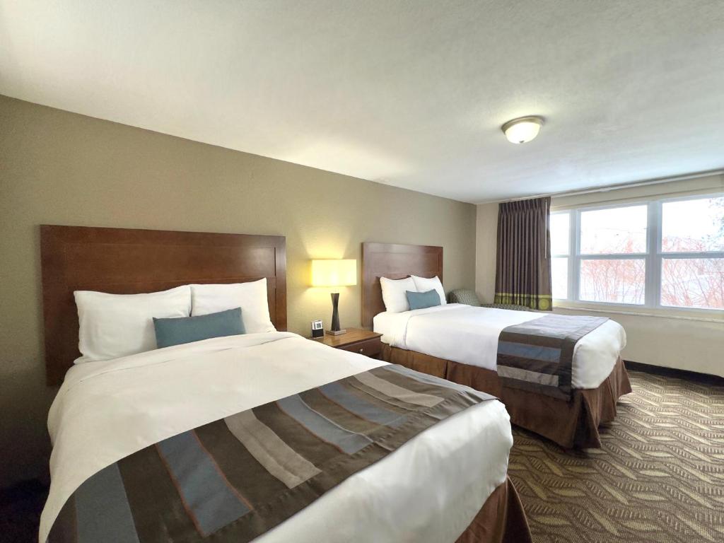 um quarto de hotel com duas camas e uma janela em Super 8 by Wyndham Greensburg em Greensburg