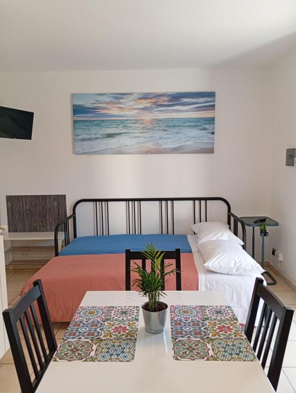 1 dormitorio con 2 camas, mesa y sillas en Sunrise, en Monterotondo