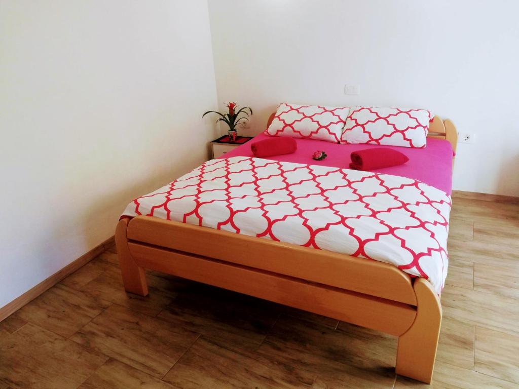 Schlafzimmer mit einem Bett mit rosa und weißer Bettwäsche in der Unterkunft Apartma SunySun in Koper