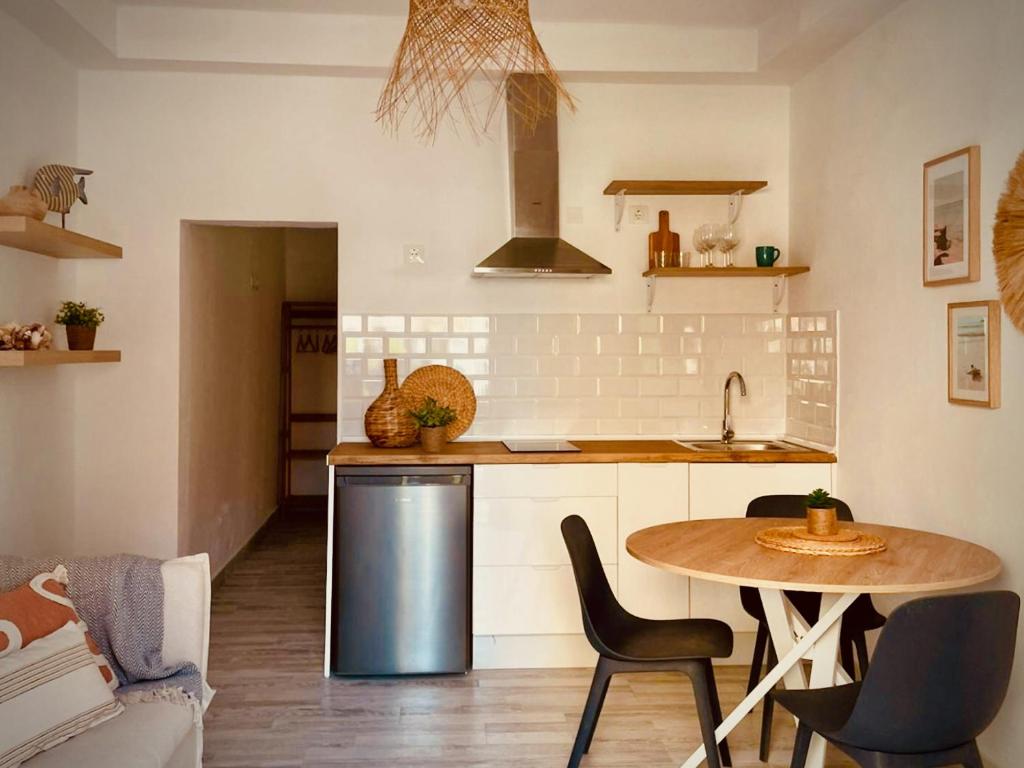 Una cocina con una mesa, un fregadero y una estufa. en Click & Guest - Casa Mama Carina B, en Agüimes