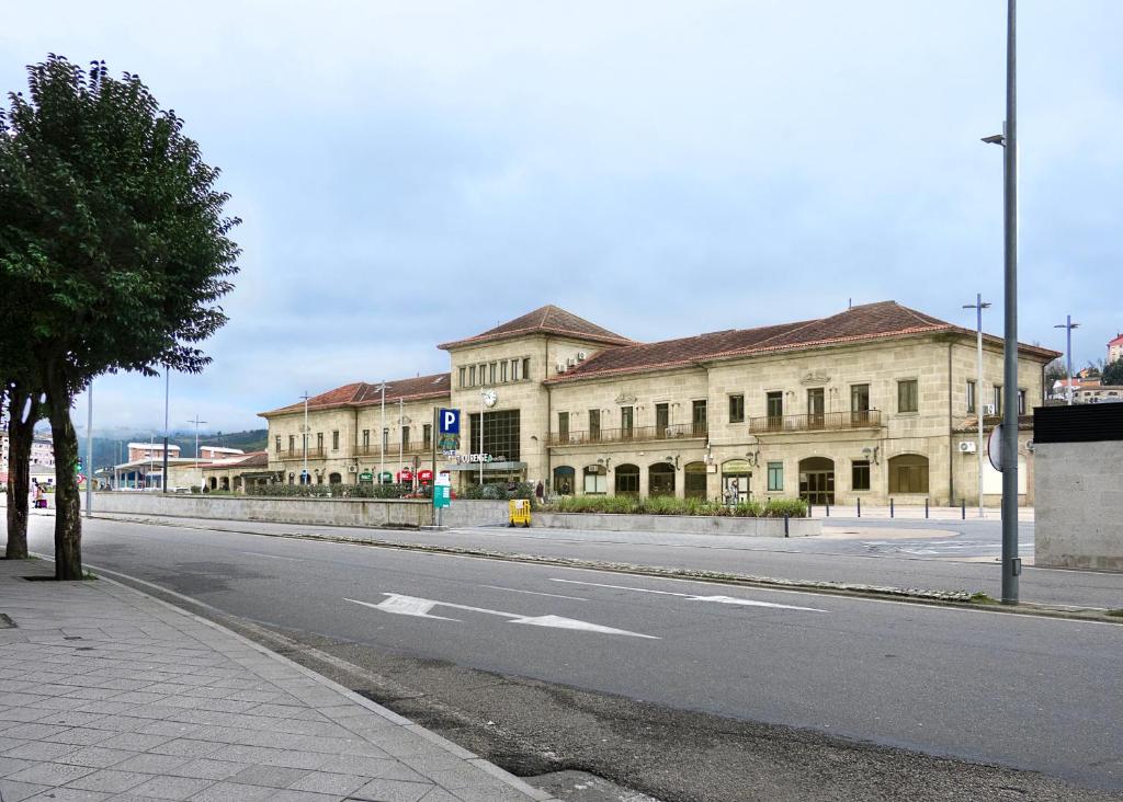an empty street in front of a large building at El Rincón de la estación in Ourense