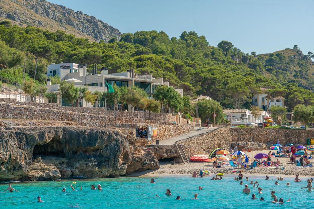 a group of people in the water at a beach at Mirador Blue K Cala Sant Vicenc in Cala de Sant Vicenc