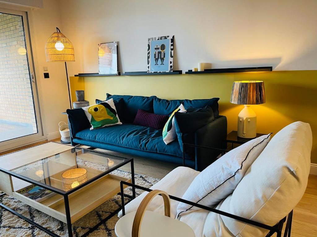 un salon avec un canapé bleu et une table dans l'établissement Au cœur du Croisé Laroche, à Marcq-en-Barœul