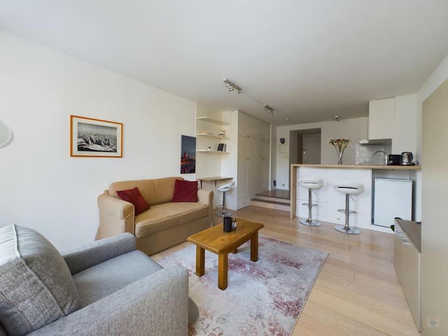 a living room with a couch and a table at Studio - central, calme et bien placé in Brussels