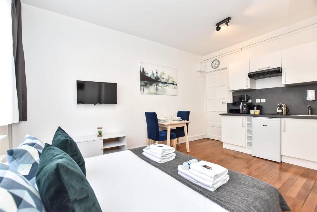 ein Wohnzimmer mit einem Bett und eine Küche in der Unterkunft Beautiful Studio 2P CharonneFaidherbe in Paris