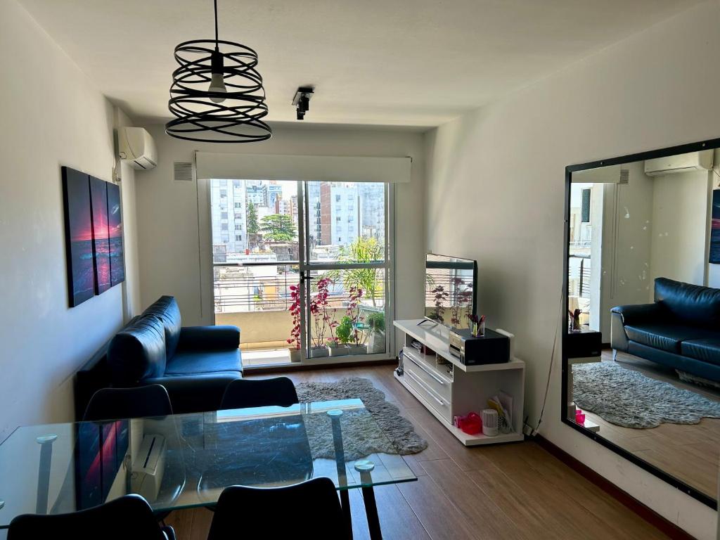 un soggiorno con divano e tavolo in vetro di Hermoso y grande departamento, ubicación ideal a Rosario