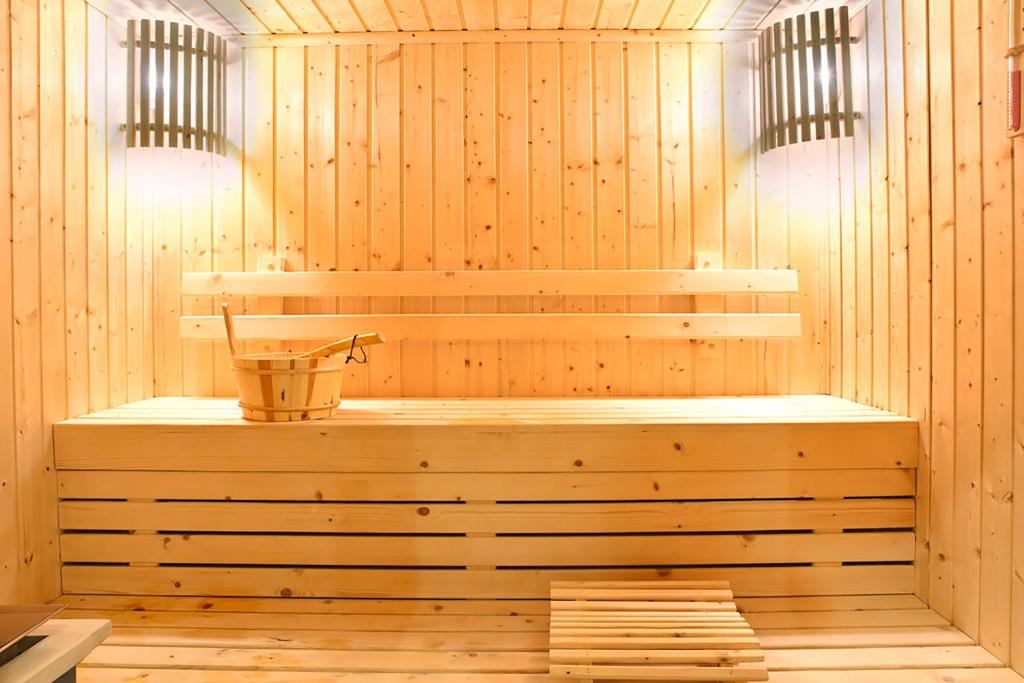 a sauna with a bench and a bucket in it at Alaçatı Wellness Garden in Alacati