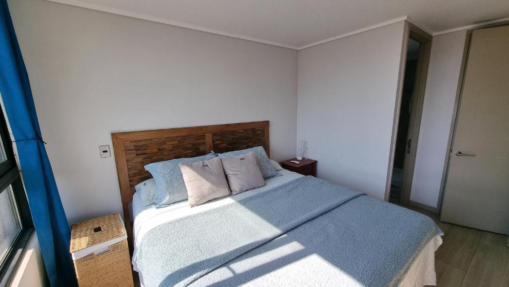 um quarto com uma cama com lençóis e almofadas azuis em SAN CRISTOBAL em Santiago