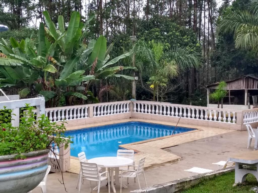 a swimming pool in a backyard with a fence around it at Chacara Branca de Neve in Biritiba-Mirim