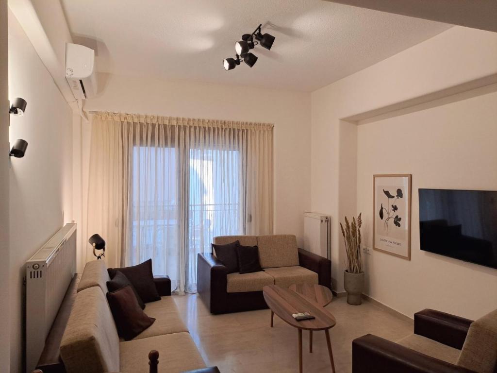 a living room with a couch and a tv at CENTER o'CLOCK in Xanthi