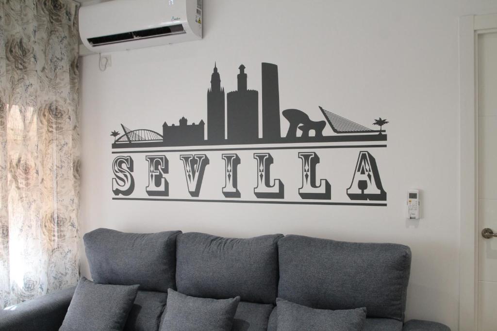 eine Couch in einem Wohnzimmer mit Schild an der Wand in der Unterkunft LUISAHOUSE, en el corazón de Sevilla y Triana in Sevilla