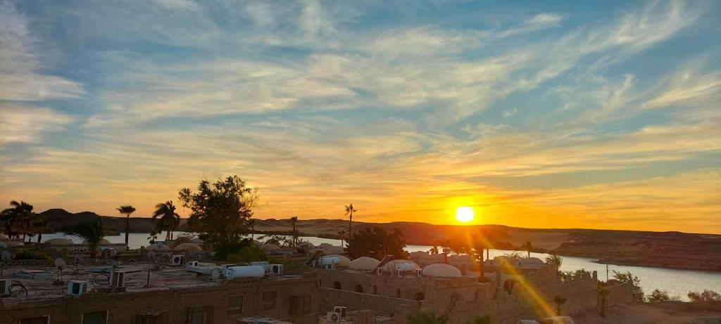 una puesta de sol sobre una ciudad con un cuerpo de agua en Sama Stars Hotel, en Abu Simbel