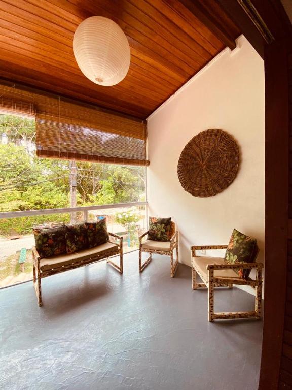 uma sala de estar com dois sofás e uma grande janela em Casa Vida Li na Ilha de Boipeba