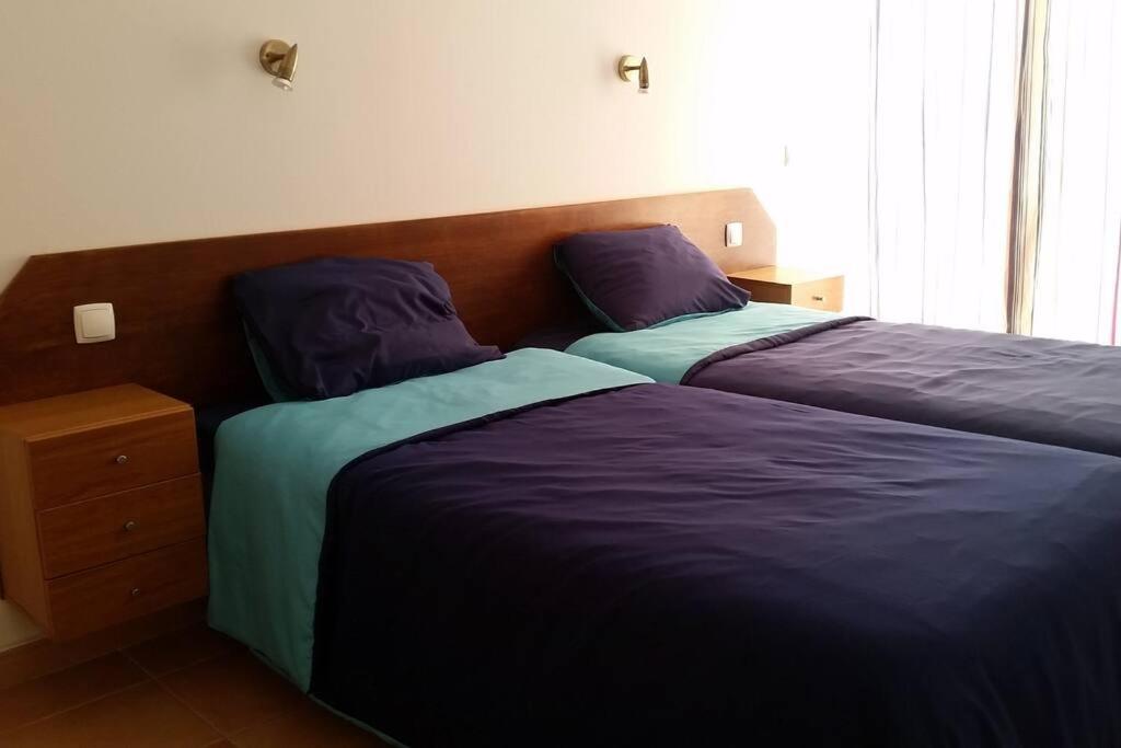 Dos camas una al lado de la otra en un dormitorio. en Sesimbra Village T1, en Sesimbra