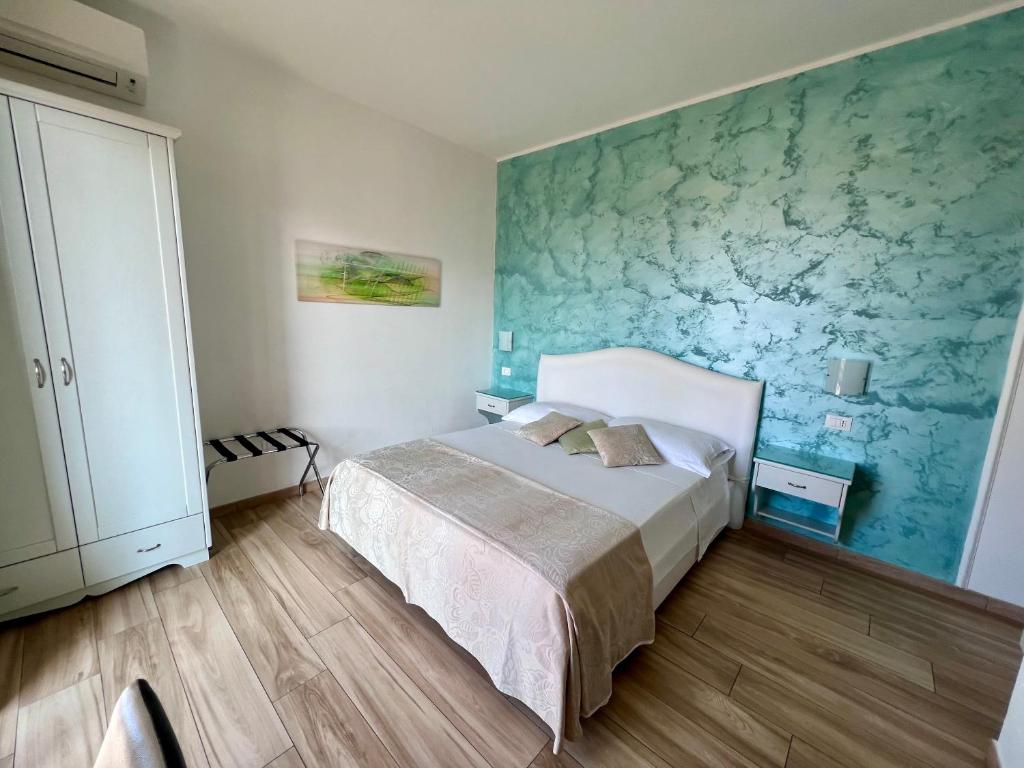 1 dormitorio con cama y pared verde en Bella Tropea Accommodation en Tropea