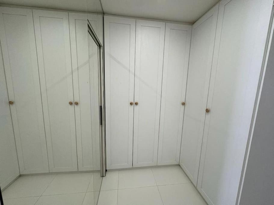 um vestiário branco com pisos brancos e armários brancos em Casa com 3 quartos e piscina - 8 min da Praia em São José de Ribamar
