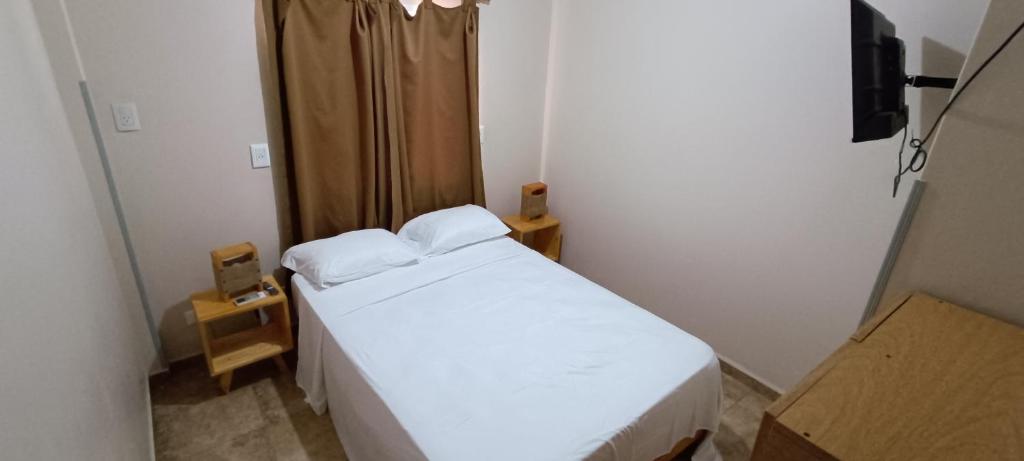um pequeno quarto com uma cama branca num quarto em Tierra Mía em Posadas