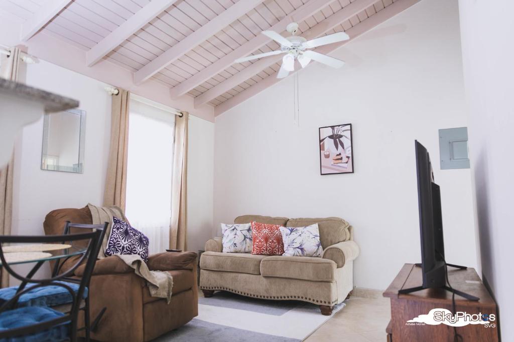 a living room with a couch and a ceiling fan at Serendipity in The Villages in Christ Church