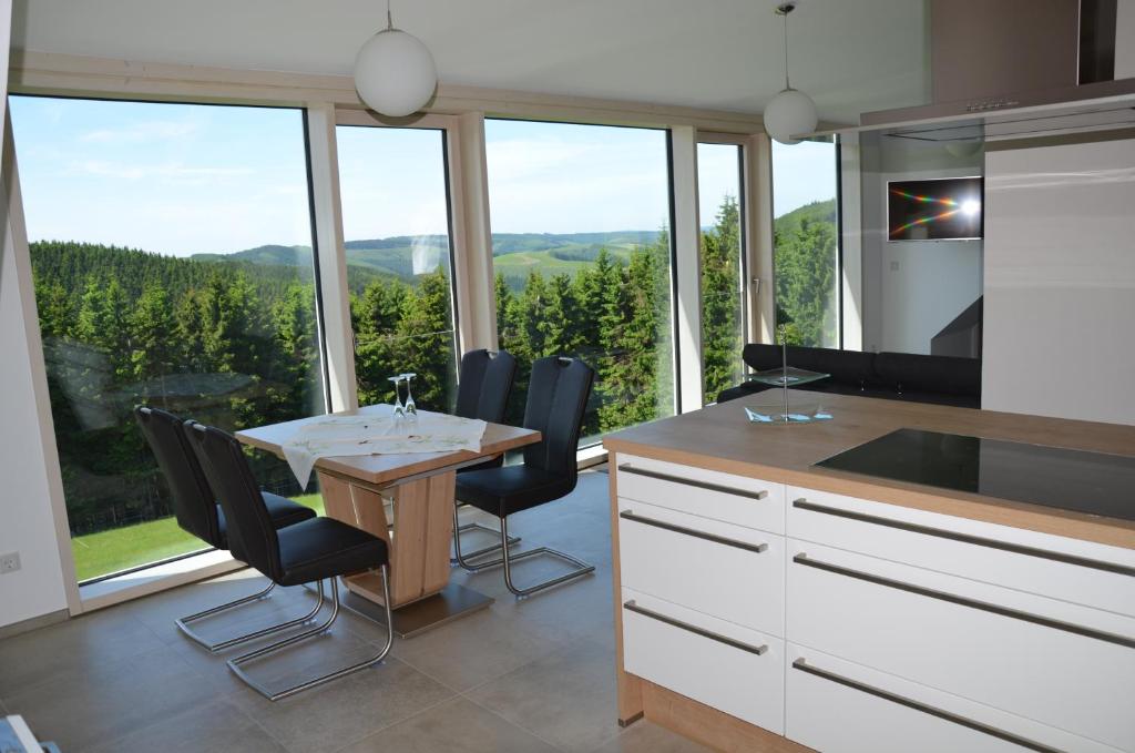 uma cozinha com mesa e cadeiras e uma grande janela em Ferienhaus zur Glocke em Winterberg