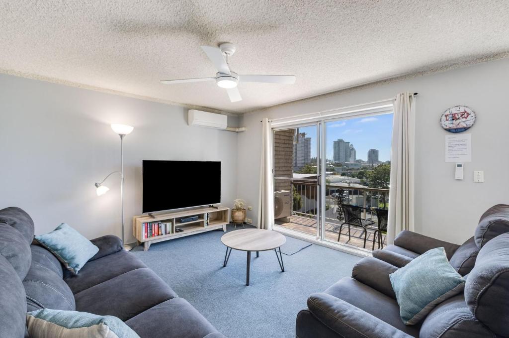 ein Wohnzimmer mit einem Sofa und einem Flachbild-TV in der Unterkunft Skyline Unit 12 in Gold Coast