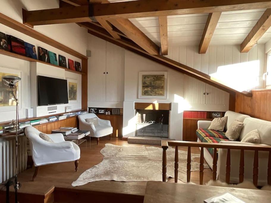 sala de estar con sofá y chimenea en Mansarda nel centro di Cortina, en Cortina dʼAmpezzo