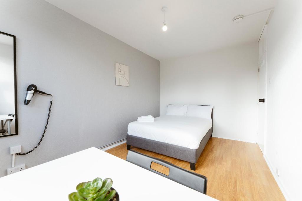 une petite chambre avec un lit et un miroir dans l'établissement Langdon Park Room, à Londres