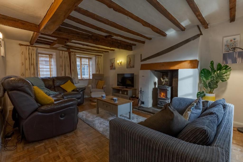 ein Wohnzimmer mit Sofas und Kamin in der Unterkunft 14th-century cosy 3-bed cottage Business stays in Bloxham
