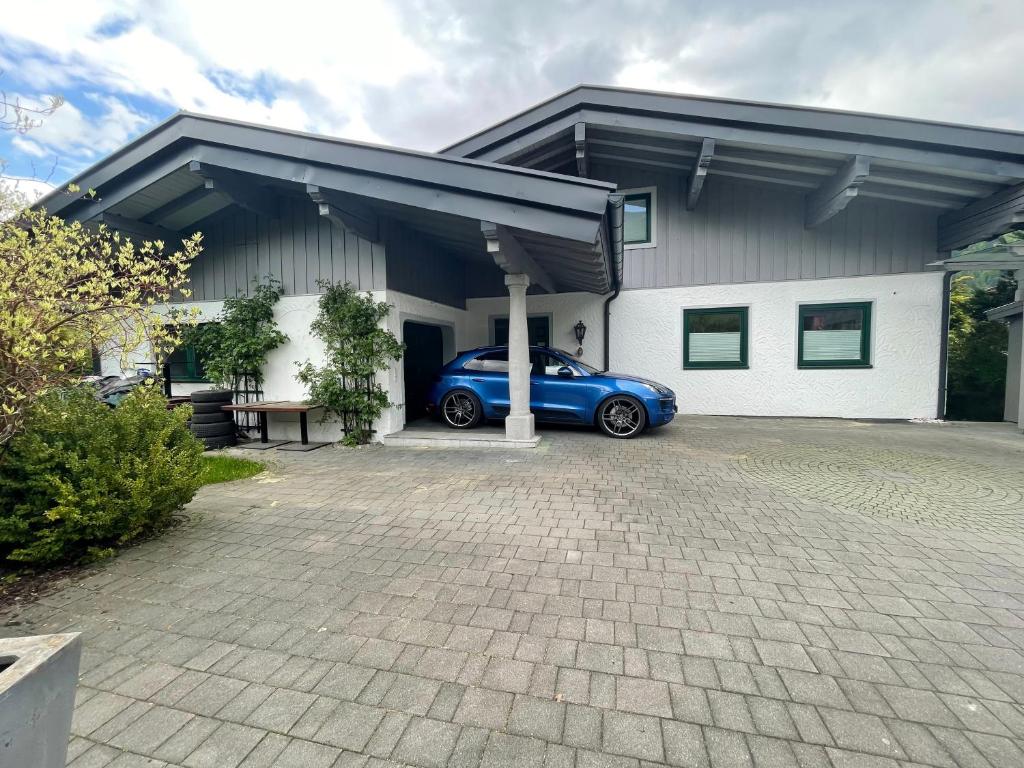 um carro azul estacionado em frente a uma casa em Kohlis Alpine Home em Bruck an der Großglocknerstraße