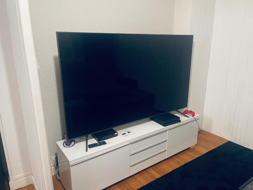 a large flat screen tv on a white entertainment center at T4 spacieux tout confort &#47; parking gratuit in Grenoble