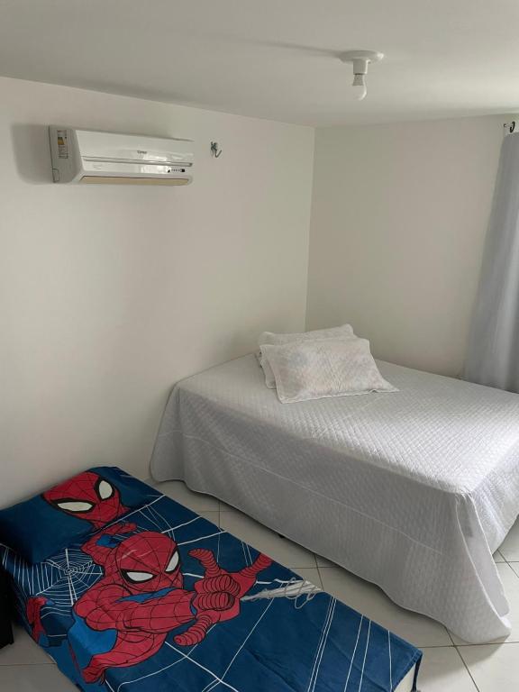 ein Schlafzimmer mit einem Bett mit einem Spinnenteppich auf dem Boden in der Unterkunft Mar e Sol Residencial em Jacuma PB in Conde