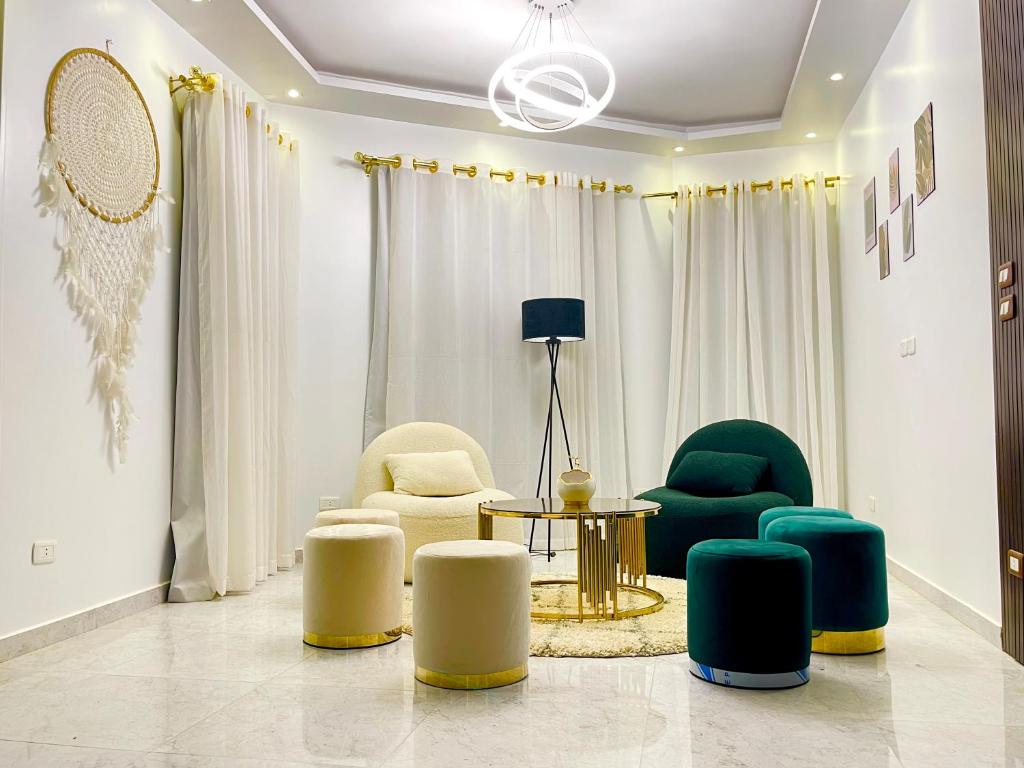 ein Wohnzimmer mit grünen und weißen Stühlen und einem Tisch in der Unterkunft A luxury apartment full furnished ultra modern in Kairo