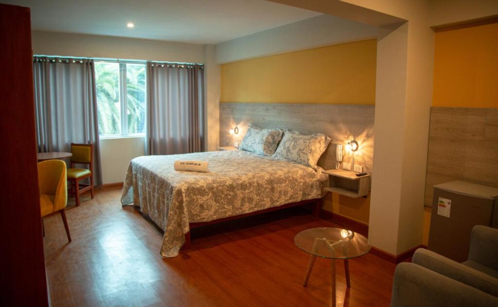 um quarto de hotel com uma cama e uma mesa em HOTEL SUDAMERICANA INN em Tacna